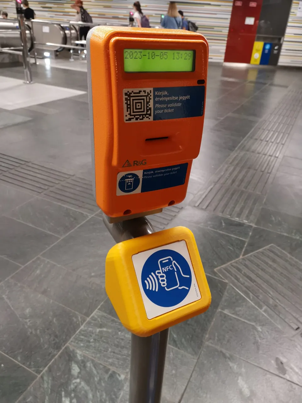 A sárga NFC-foglalat a teljes jegyérvényesítő oszlopon egy budapesti metróállomáson