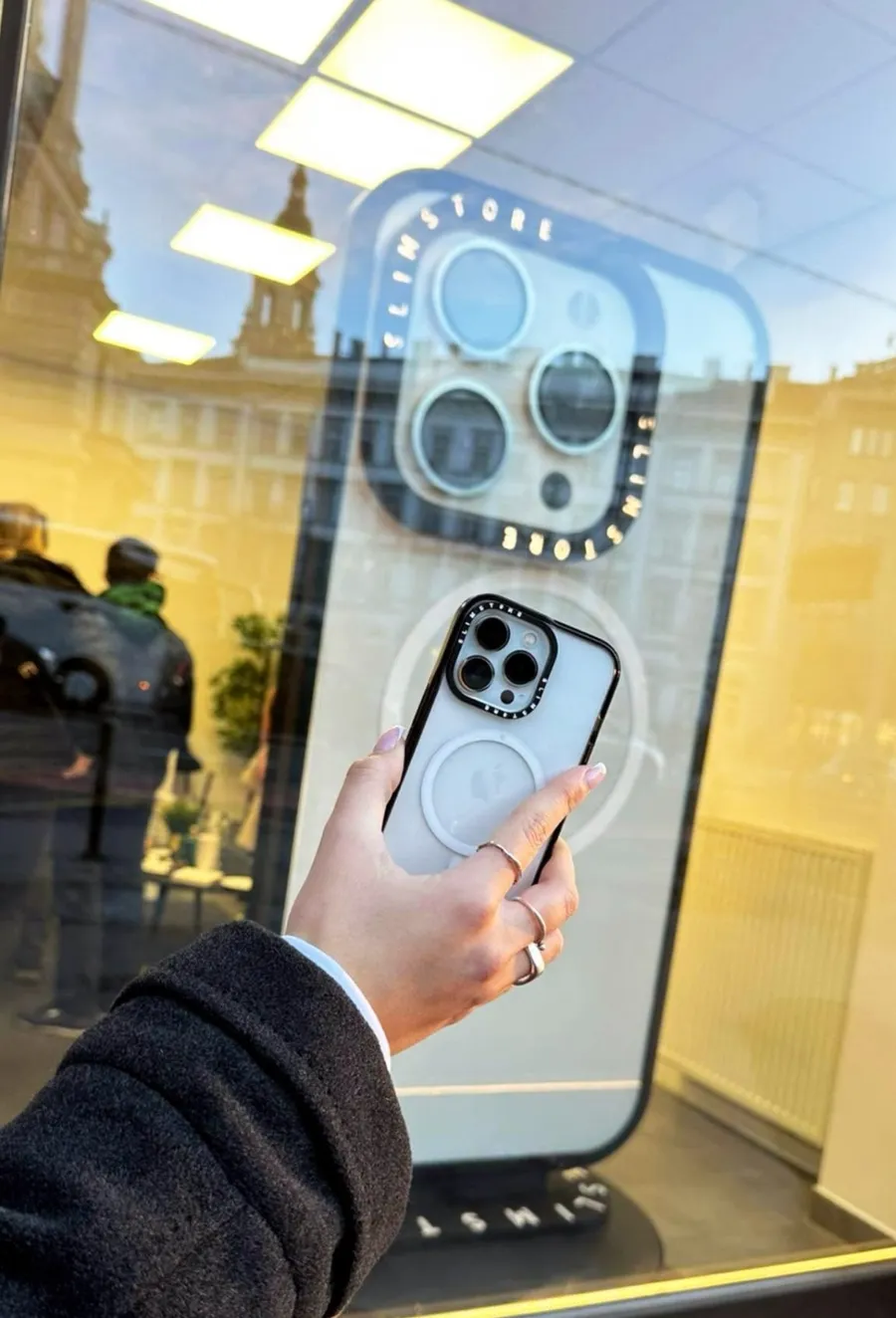 Az óriás iPhone-replika kameramodulja közelről, a kirakatüvegen át
